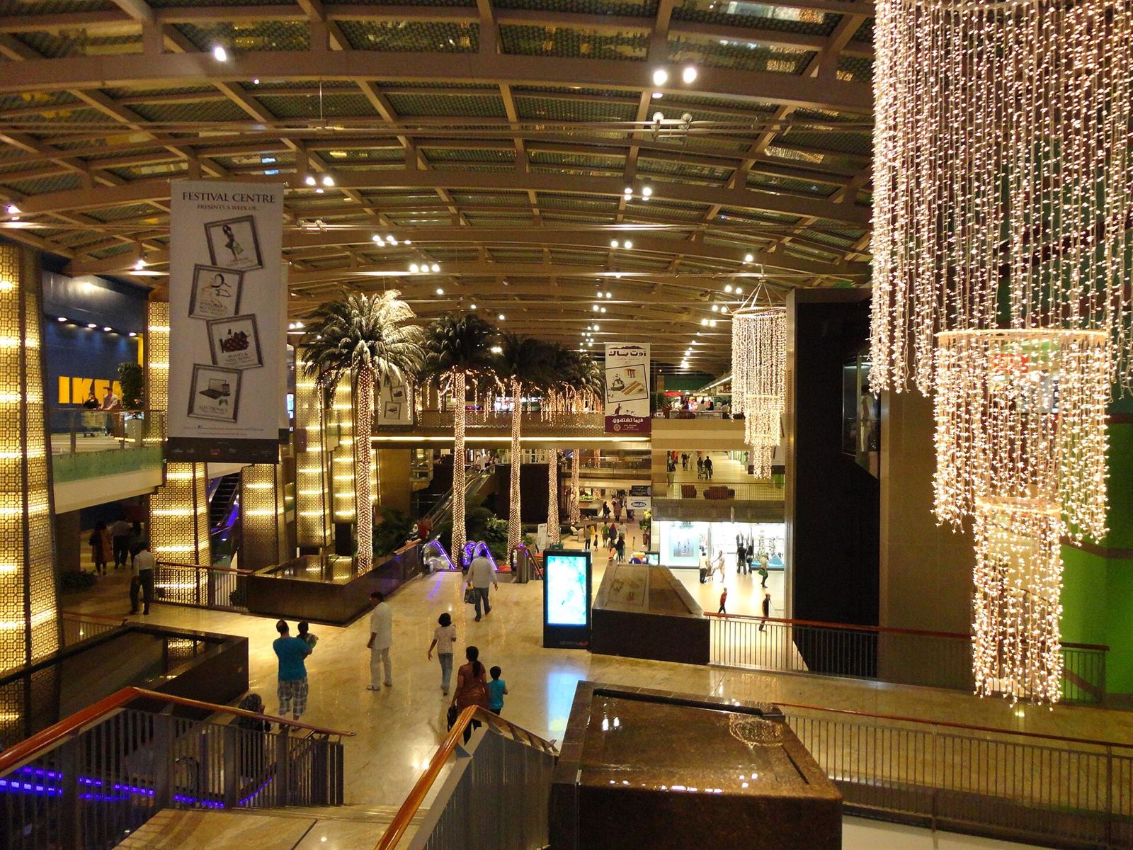 Shopping mall interior in Dubai with palm trees and lights