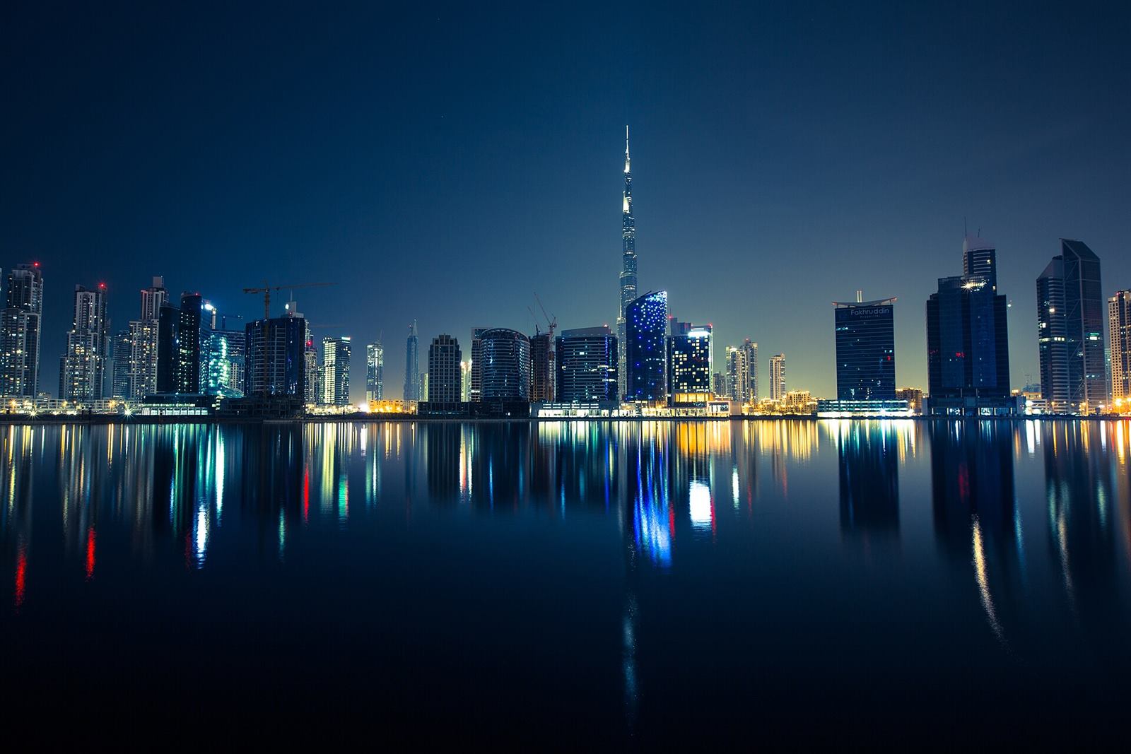 Dubai skyline at night with the Burj Khalifa reflected in the water